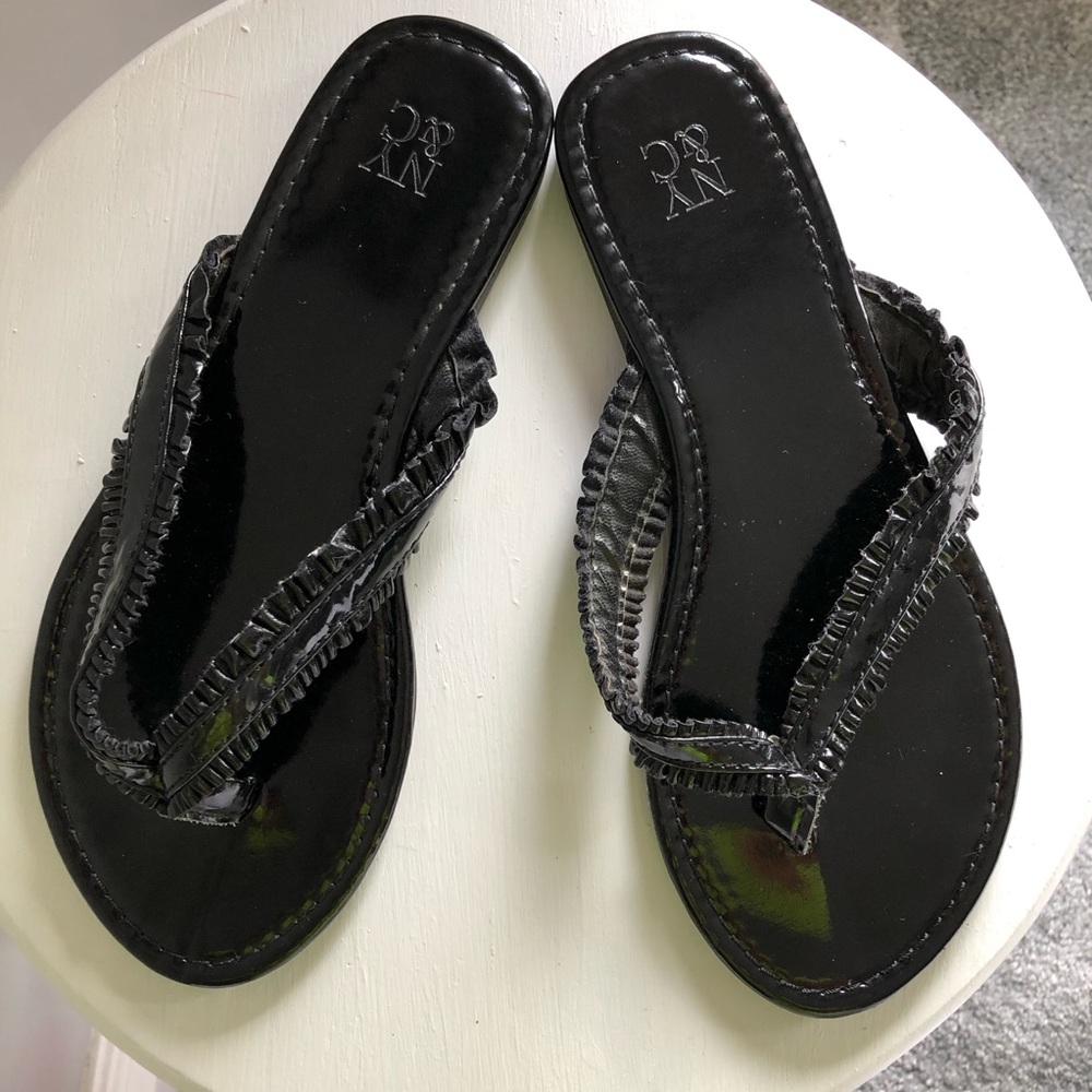 Shiny black flip flops